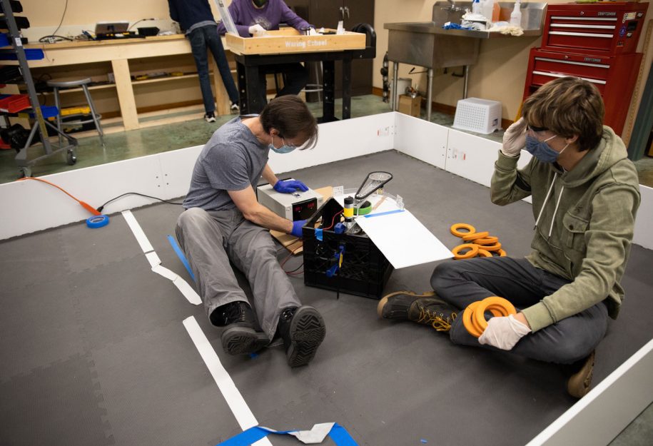 A teacher and student building a robot