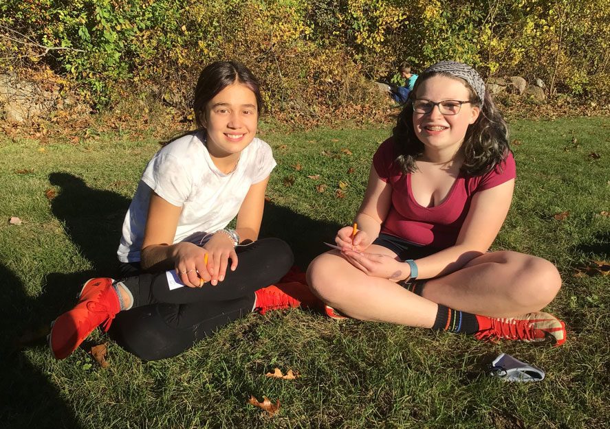 female students sitting together on the grass