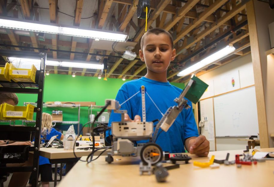 a young boy building a robot